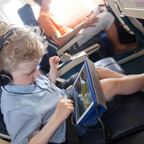 Bambino in aereo con il tablet