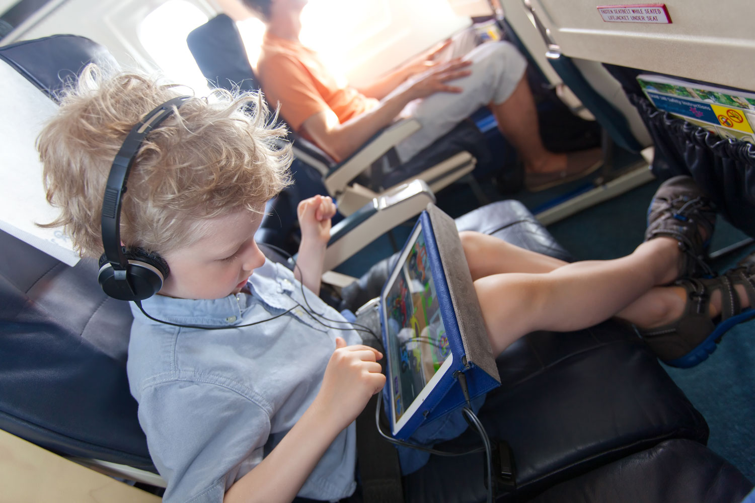 Bambino in aereo con il tablet
